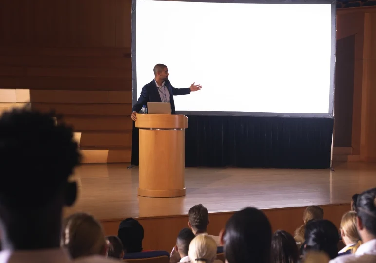 Speaker presenting in a modern auditorium.